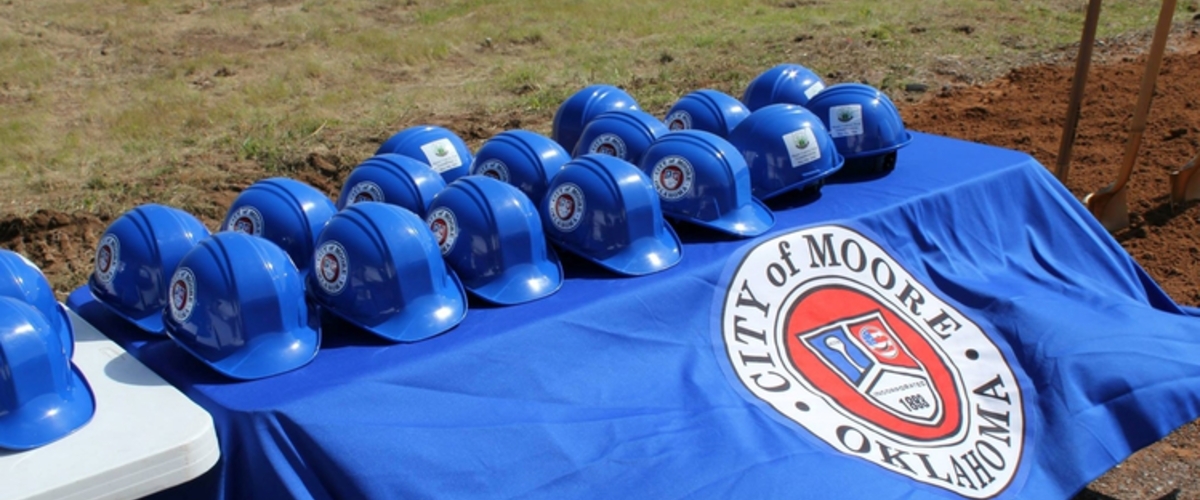 City of Moore hard hats on a table with the City of Moore seal